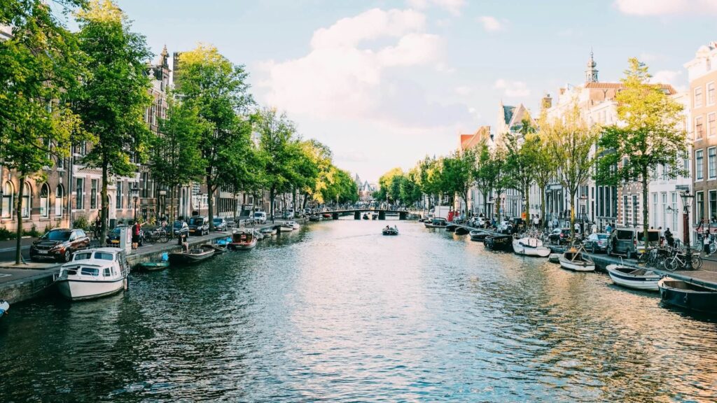 Amsterdamse gracht met rondvaartboten toont alcoholgebruik op toeristische boten binnen een stedelijk vaargebied.