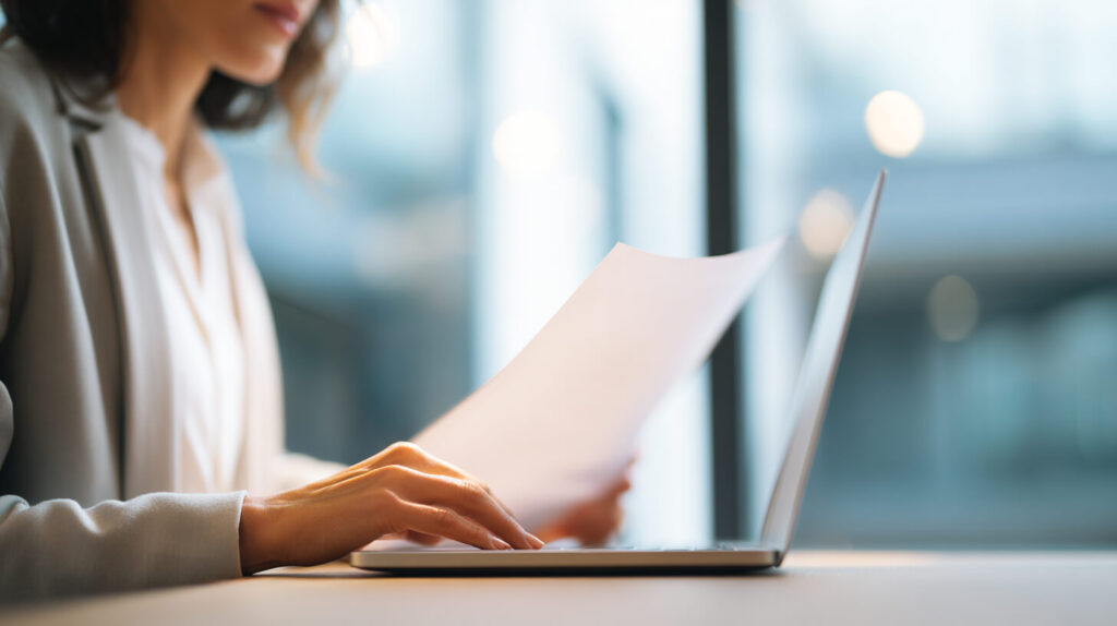 HR-medewerker verwerkt documenten van financieel personeel met aandacht voor privacy en gegevensbescherming.