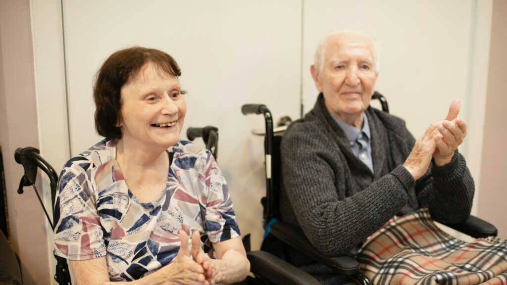 Twee ouderen in rolstoel nemen deel aan activiteit binnen zorginstelling volgens thuiszorg regels Nederland